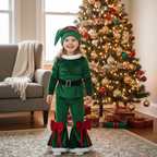 Flicka i grön kostym vid julgranen